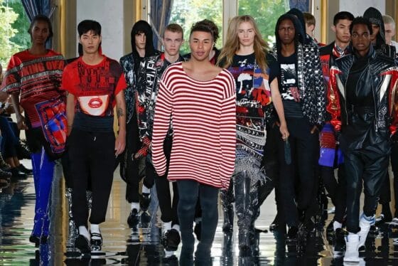 Oliver Rousteing wearing a red and white strip sweater surrounded by male and female models from Balmain Spring 2019 show